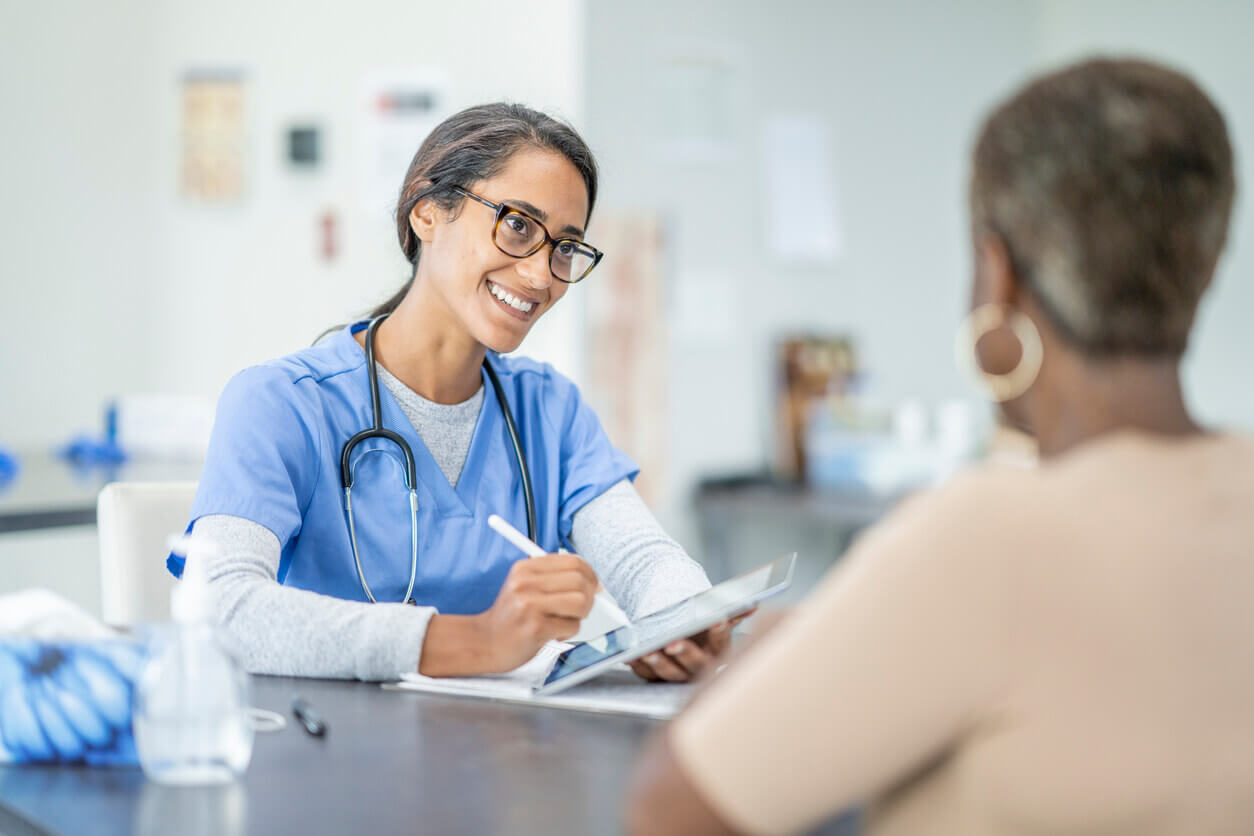 An African American senior woman is at a medical appointment with a nurse practitioner.